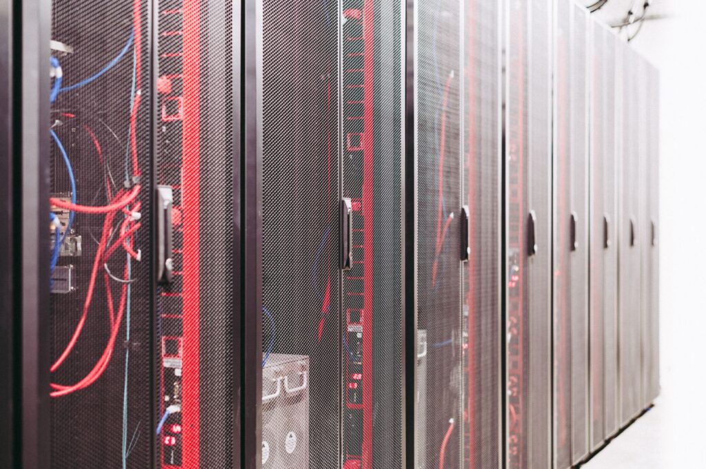 Rady čiernych serverových rackov s červenými a modrými káblami v datacentre